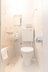 a white bathroom with a toilet and a sink at 墨田漢舎3号 in Wada