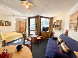 a living room with a blue couch and a bed at Studio cabine + coin nuit, 6 couchages, Vars Les Claux, proche pistes et commerces - FR-1-330B-174 in Vars