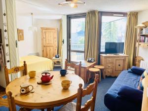 a living room with a table and a couch at Studio cabine + coin nuit, 6 couchages, Vars Les Claux, proche pistes et commerces - FR-1-330B-174 in Vars +3 photos