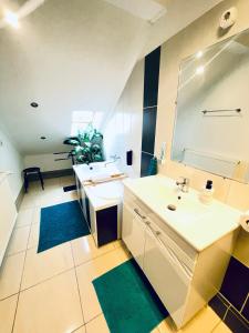a bathroom with two sinks and a mirror at Alpesi Apartman Downtown in Sopron
