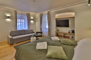 a bedroom with a large bed and a couch at Céhes Guesthouse in Târgu Secuiesc