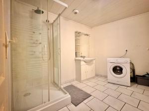 a bathroom with a shower and a washing machine at Le logis de Gavrelle in Gavrelle