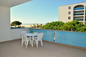 a table and chairs on a balcony with the beach at Residence Itaca in Bibione