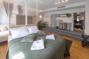 a bedroom with a large bed with two towels on it at Céhes Guesthouse in Târgu Secuiesc