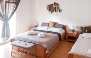 Un dormitorio con dos camas y una ventana. en 2 Bedroom Amazing Apartment In Lopar, en Lopar