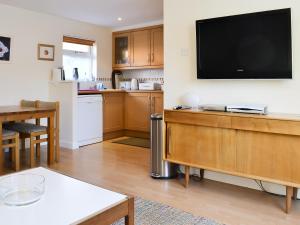 a living room with a flat screen tv on a wall at Bruich Cottage in Newtonmore