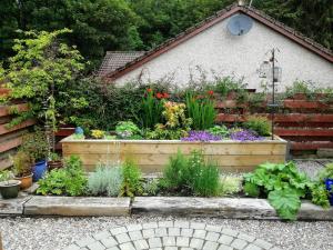 a garden with a bunch of flowers and plants at Bruich Cottage in Newtonmore