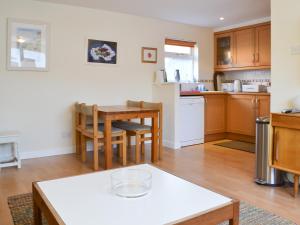 a kitchen and living room with a table and chairs at Bruich Cottage in Newtonmore