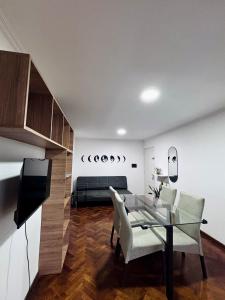 a dining room with a glass table and a couch at Departamento Frente Campus UNC in Cordoba