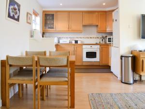 a kitchen with wooden cabinets and a table and chairs at Bruich Cottage in Newtonmore
