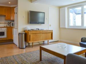 a living room with a flat screen tv on the wall at Bruich Cottage in Newtonmore