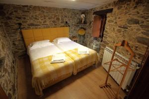 a bedroom with a large bed in a stone room at Casa do Talasnal Montanhas de Amor in Lousã