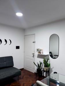 a living room with a black couch and a mirror at Departamento Frente Campus UNC in Cordoba