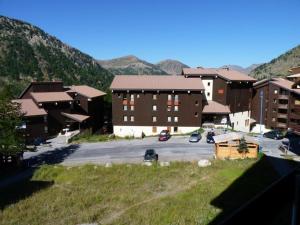 Un estacionamiento con un montón de edificios y montañas. en Appartement Spacieux pour 9 Pers., Balcon Sud-Ouest, Wifi Inclus, Proche Pistes - Isola 2000 - FR-1-292-109, en Isola 2000
