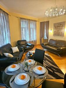 Old Town 2 Bedroom Apartment with Stunning River View by Dome Square and Presidential Castle في ريغا: غرفة معيشة مع طاولة وأثاث جلد أسود