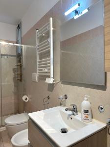 a bathroom with a sink and a toilet and a mirror at Modern apartment - Salento Guest House in Monteroni di Lecce +23 photos