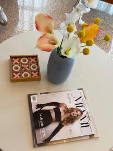 a magazine and a vase with flowers on a table at Blue Flamingo Suites in Miami Beach