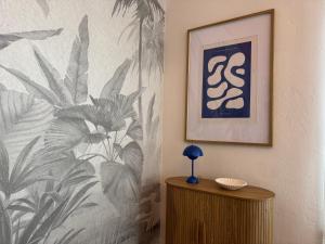 a room with a wall with a picture and a table at Blue Flamingo Suites in Miami Beach