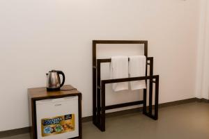 a bathroom with a towel rack and a mirror at Fathers Place Hiriketiya in Dickwella