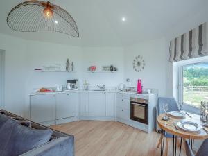 a kitchen with white cabinets and a table in a room at Deer's Leap - Uk50121 in Bodelwyddan