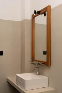 a bathroom with a white sink and a mirror at Fathers Place Hiriketiya in Dickwella