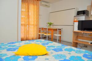 a bedroom with a bed with a yellow pillow on it at Residence Itaca in Bibione