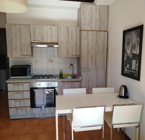 a kitchen with a table and chairs and a stove at Carducci Apartment - THE V Collection in Turate