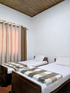 エッラにあるFelix Holiday Bungalowの部屋に並んで置かれた2つのベッド