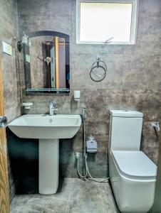 エッラにあるFelix Holiday Bungalowの洗面台、トイレ、鏡のあるバスルーム +3枚の写真