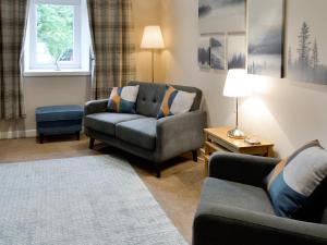 ein Wohnzimmer mit einer Couch und einem Sessel in der Unterkunft Blackmill Cottages No 2 in Taynuilt