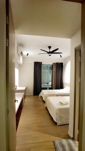 a bedroom with two beds and a ceiling fan at Seaview Cozy BS Homestay in Kota Kinabalu