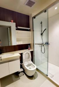 a bathroom with a toilet and a glass shower at Seaview Cozy BS Homestay in Kota Kinabalu