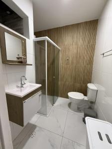 ein Badezimmer mit Dusche, Toilette und Waschbecken in der Unterkunft Brisas Beach casa 05 in Praia do Frances