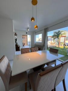 ein Esszimmer mit einem weißen Tisch und Stühlen in der Unterkunft Brisas Beach casa 05 in Praia do Frances + 26 Fotos