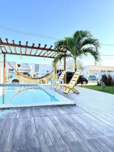 ein Swimmingpool mit Hängematte und Schaukel in der Unterkunft Brisas Beach casa 05 in Praia do Frances