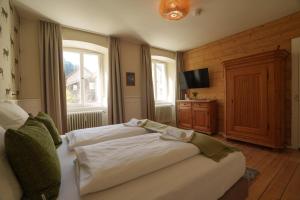 a bedroom with two beds and a television in it at Altes Forsthaus - Fewo "Wiesental", privater "Spa" mit Sauna, Wanne und Relaxliegen, Todtnau- Feldberg in Todtnau