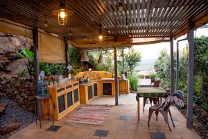 an outdoor kitchen with a wooden ceiling and a table at Embibi Mindfulness Cabins in Ngong