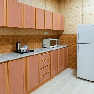 a kitchen with a white microwave and a refrigerator at المواسم in Tabuk
