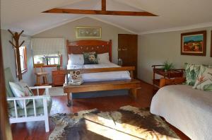 a bedroom with a large bed with a wooden headboard at Kudusdrift Farmstay in Vaalwater