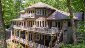 a house with a wrap around deck in the woods at Amitola at Yonahlossee in Boone