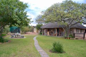 a house with a grassy yard with a table and a bench at Kudusdrift Farmstay in Vaalwater