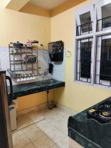 una cocina con encimera y ventana en Sunrise Homestay & Lodge, en Guwahati