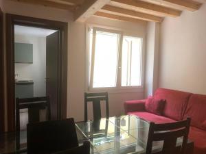 a living room with a red couch and a glass table at Carpi Centro in Carpi