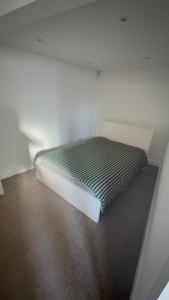 Bett in einem weißen Zimmer mit in der Unterkunft Bling Paradise in Potters Bar