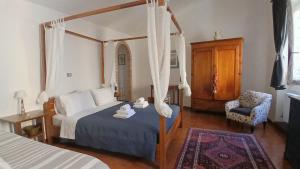 a bedroom with a canopy bed and a chair at Il Bagolaro - Alloggio turistico in Tuscania