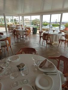 een eetkamer met tafels en stoelen met borden en wijnglazen bij Apart Edificio Vanguardia frente al mar in Punta del Este