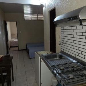 a kitchen with a sink and a stove top oven at A Pousada da Praia in São Luís