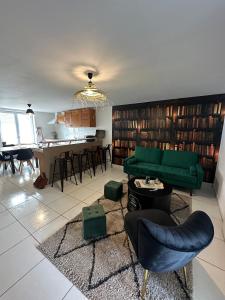 een woonkamer met een groene bank en een aantal stoelen bij La Maison des Ormes in Faremoutiers