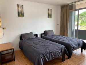 twee bedden in een kamer met een raam bij our home at lanta in Koh Lanta