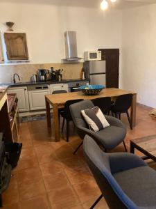 een keuken met een houten tafel en stoelen en een keuken met een aanrecht bij L' ensoleilladou in Quinson +36 foto's